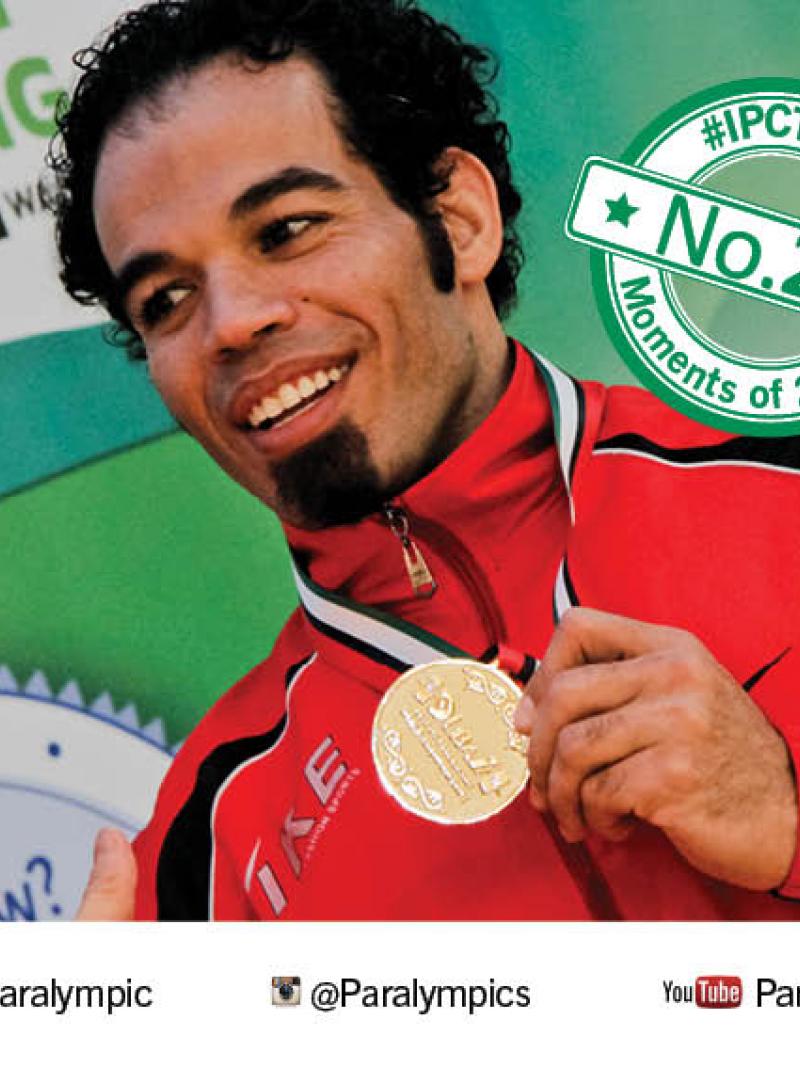 Sherif Osman holds up his gold medal smiling
