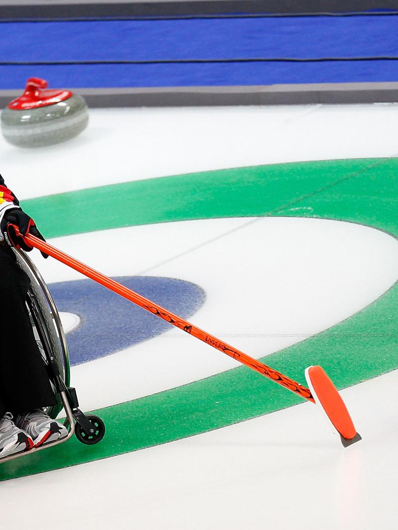 Man in wheelchair on the ice, pointing on a point on the ice