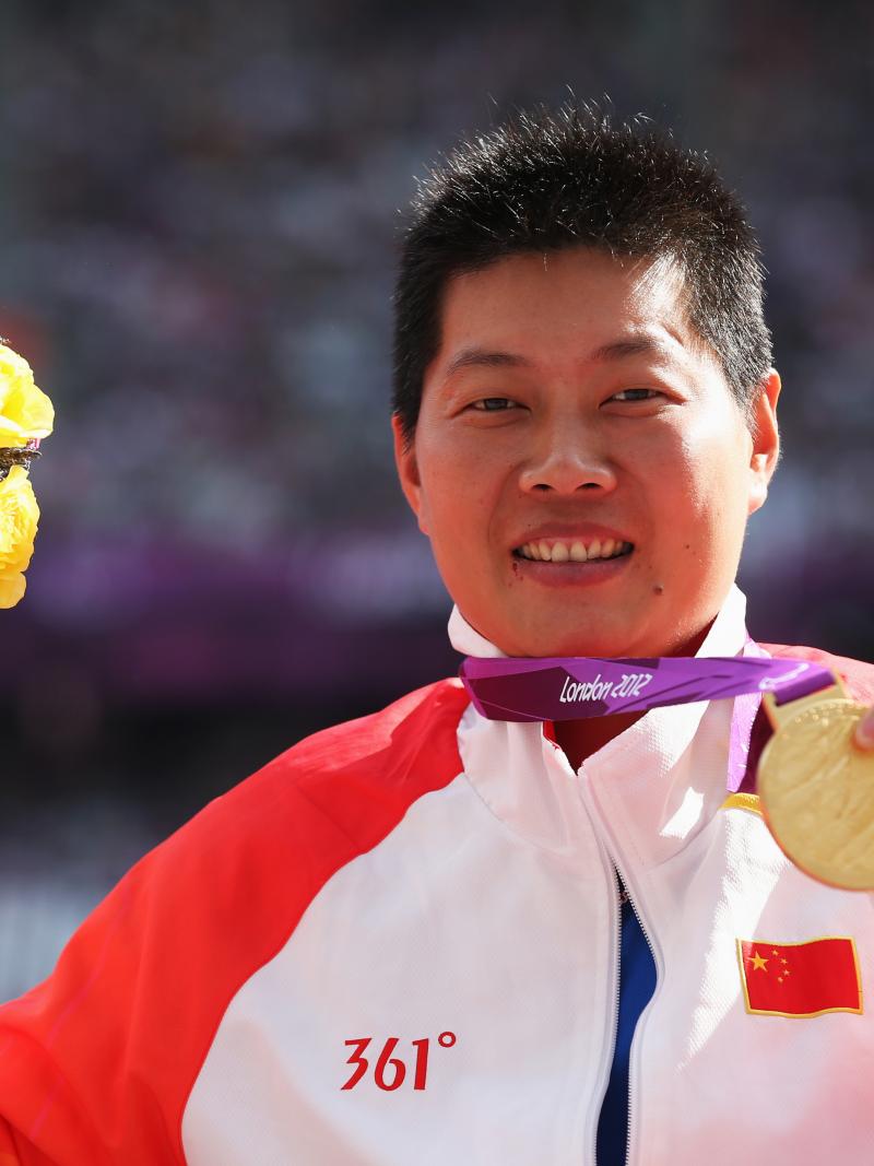 Portrait shot of women showing her medal to the camera.