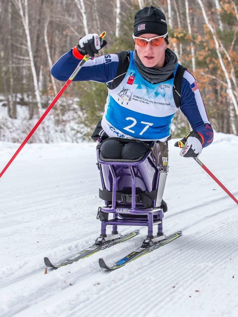Women in sit ski on snow