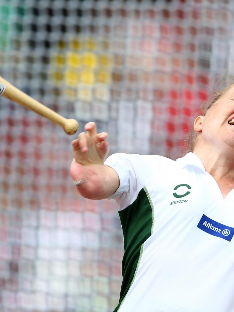 Upper body of a women who is throwing a club