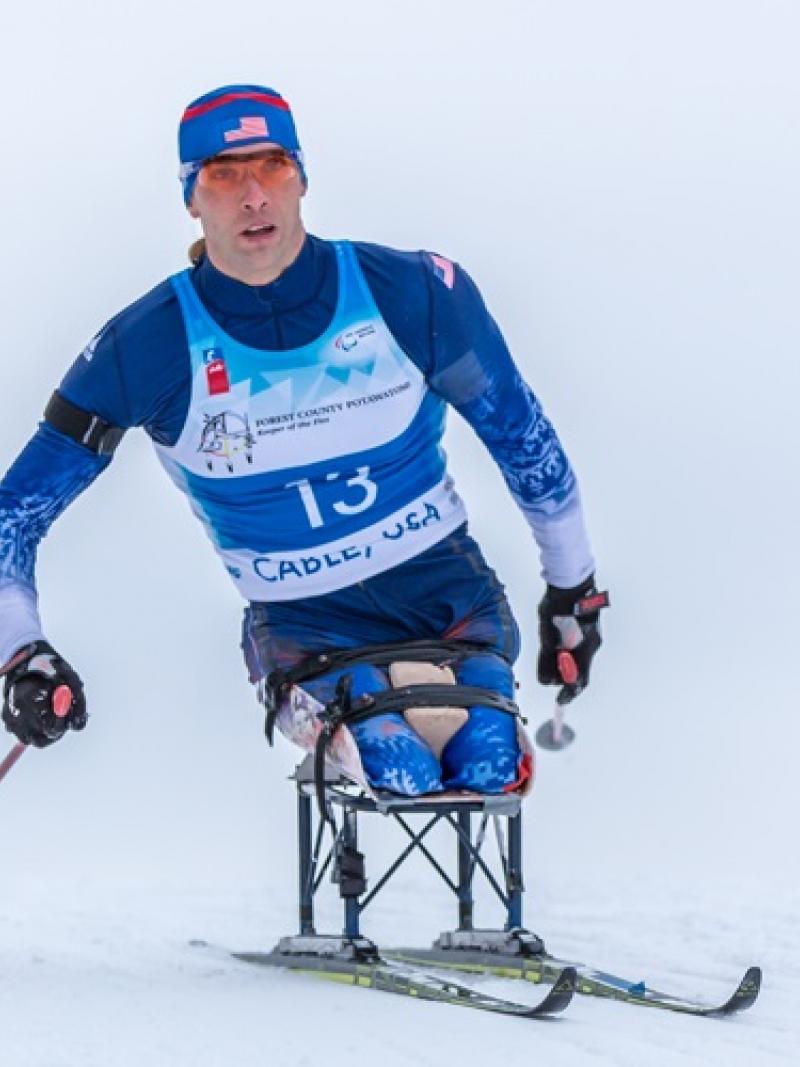Man in sit ski doing cross country skiing