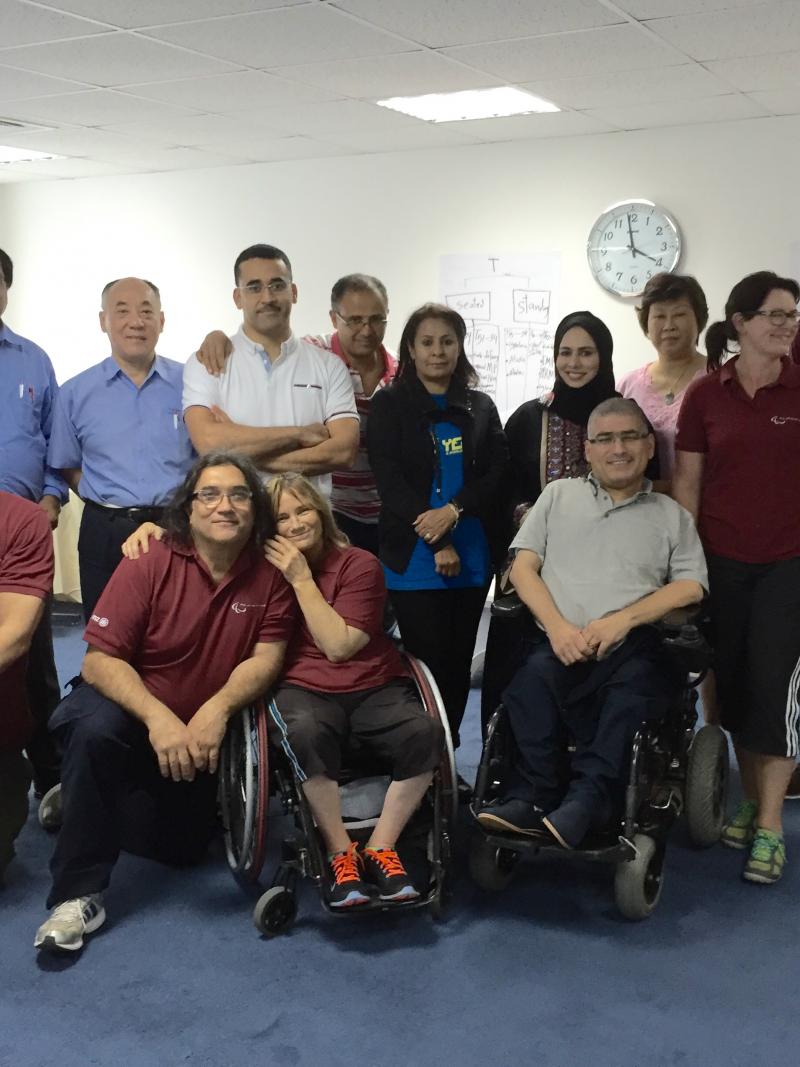 Group picture of people standing sitting and sitting in wheelchairs
