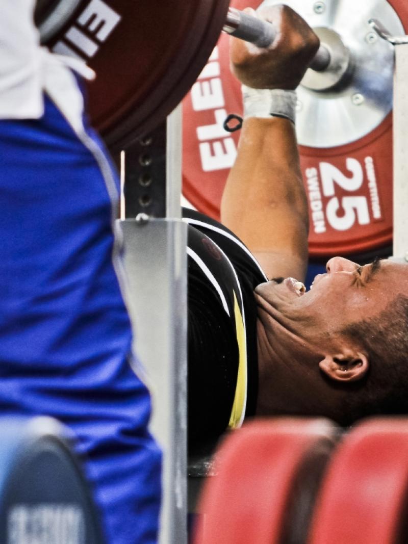 A powerlifter tries to lift the bar.