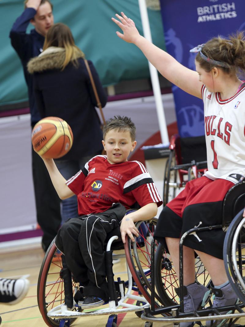 Two people in wheelchair playing basketball