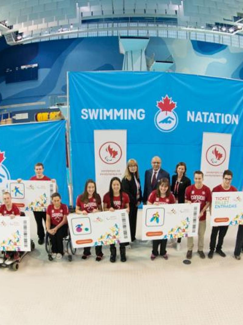 Group shot of athletes and officials in a swim stadium