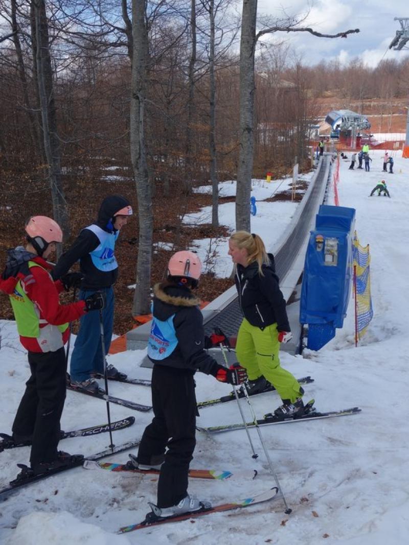 A group of youngsters are taught how to ski