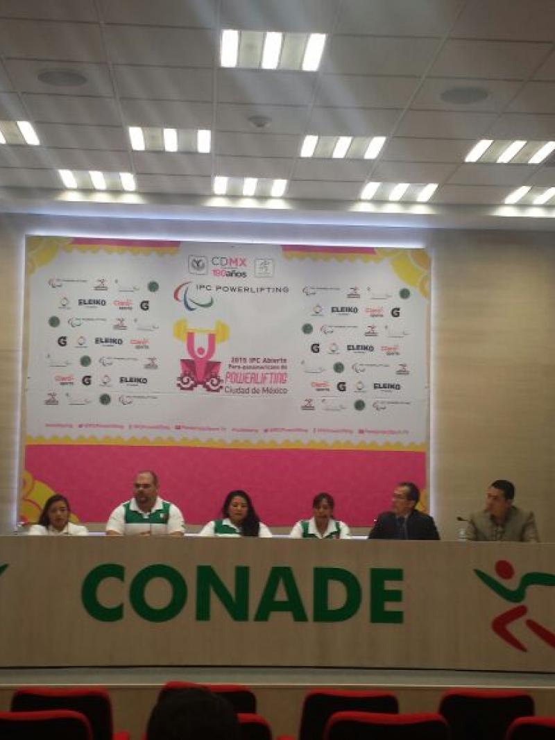 Seven people on a podium during a press conference