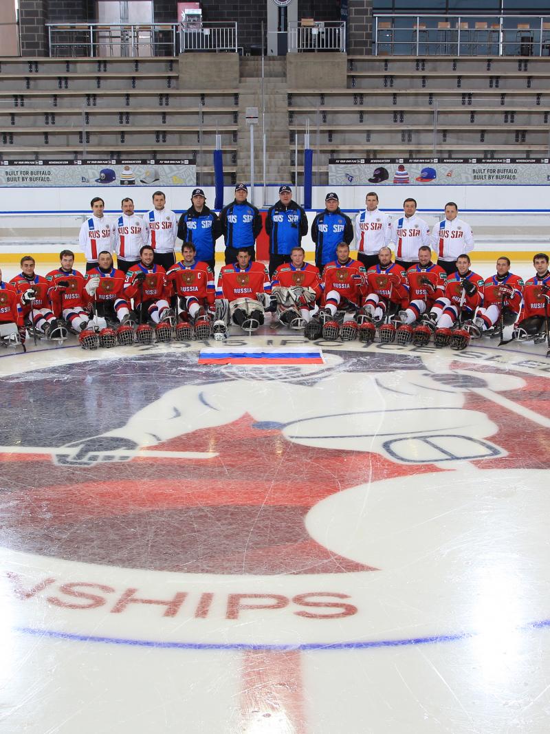 Ice sledge hockey players and coaches have a team photo