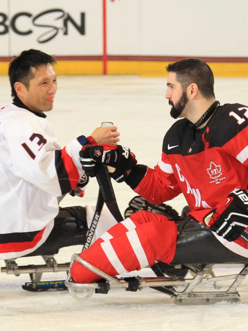Canada's Greg Westlake, right, shakes hands with Japan's Mamoru Yoshikawa after their preliminary round game at Buffalo 2015.