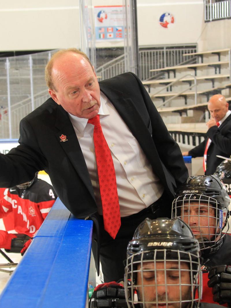Ice sledge hockey coach talking to his players.
