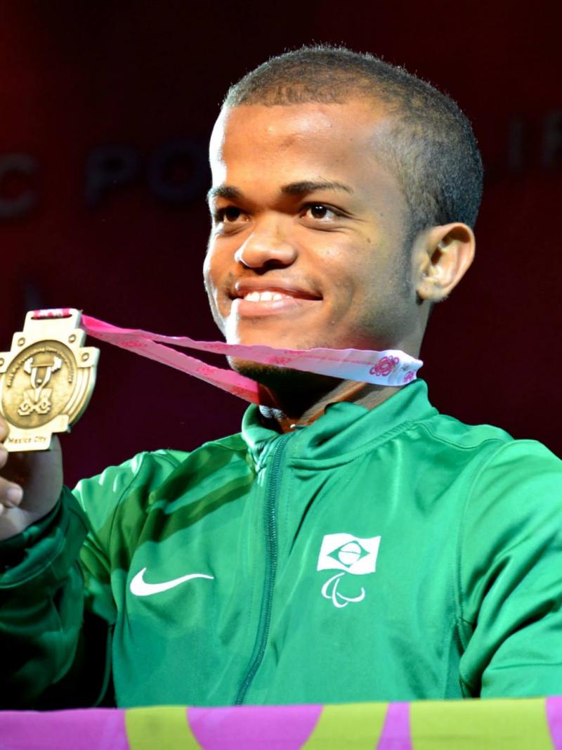 Man smiling, showing his medal