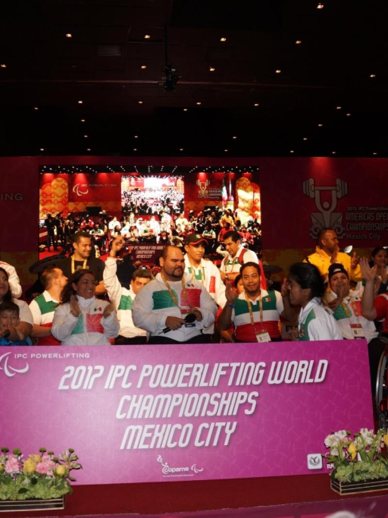 Group shot on a stage with a big sign in front