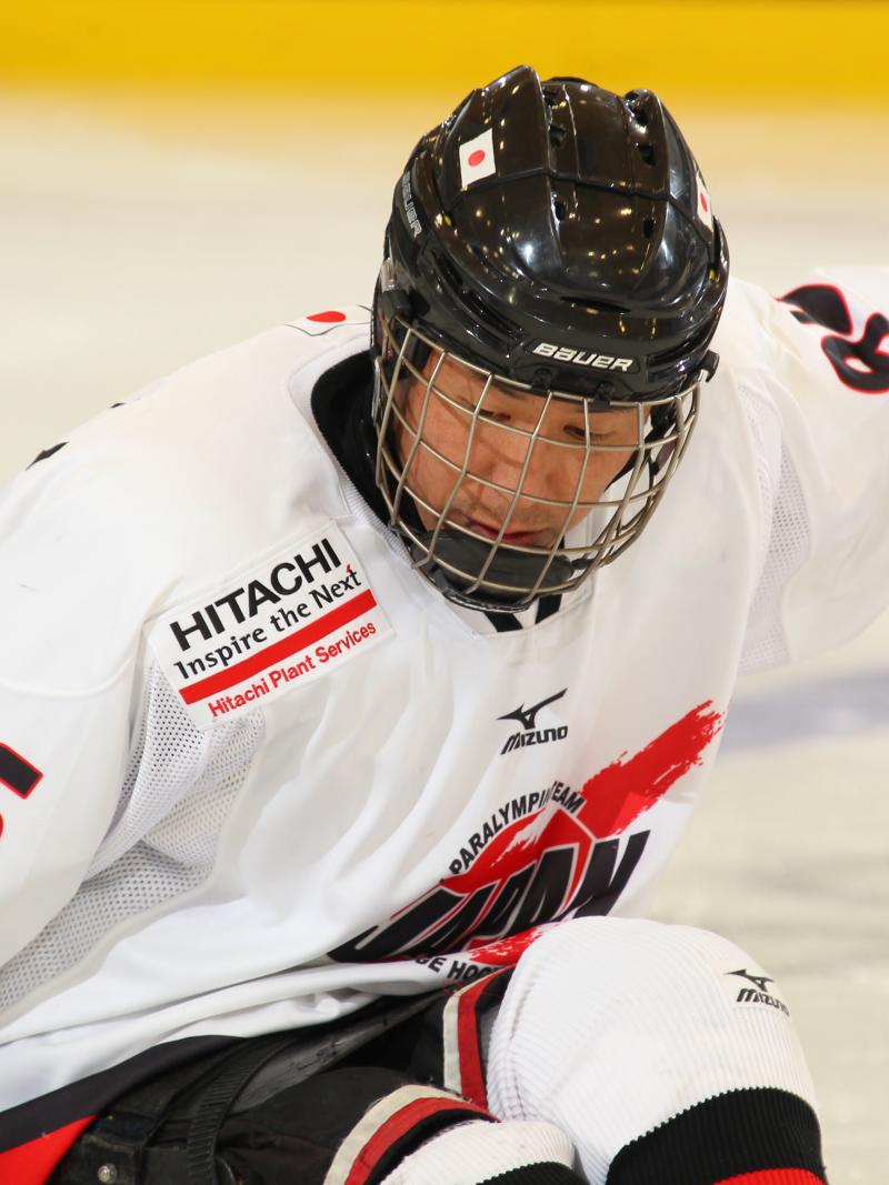 Man in white jersey and black helmet on a sledge