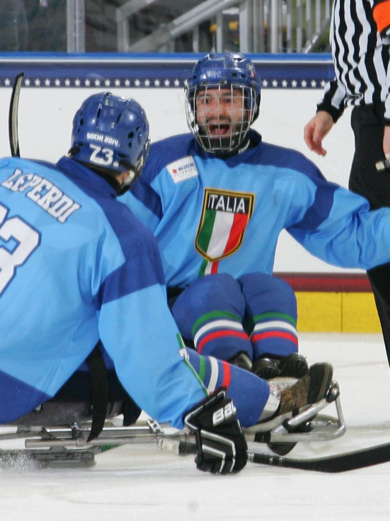 Two sledge hockey players in blue jerseys on the ice