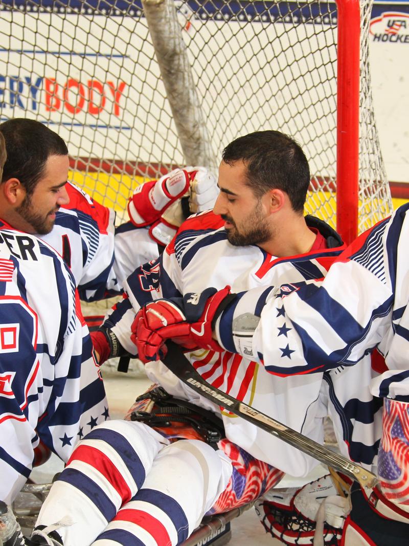 Group of sledge hockey players celebrating on the ice