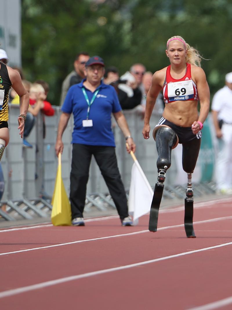 A group of female blade runners sprinting down the 100m straight.