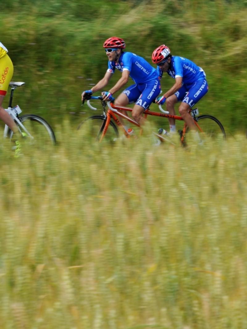 Three tandems with six cyclists surrounded by nature