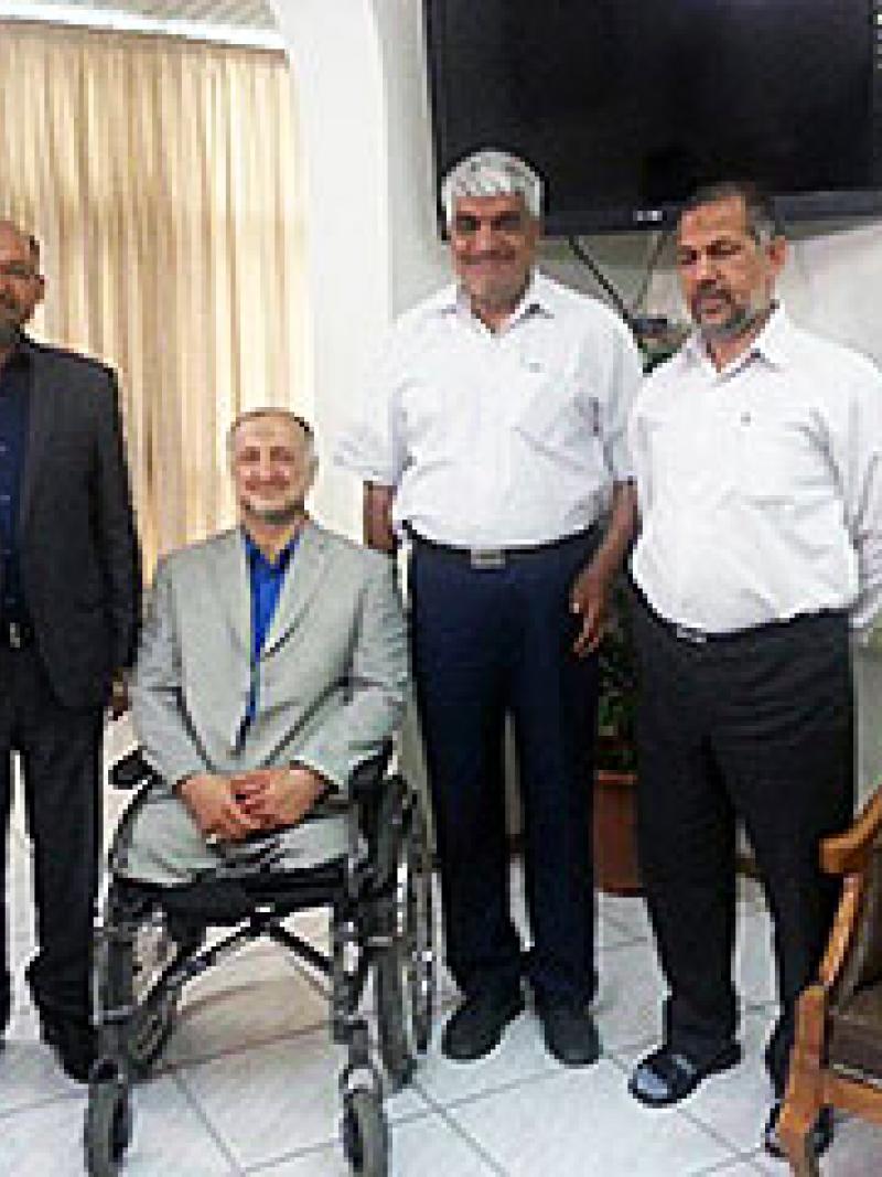 Four men pose together inside an office.