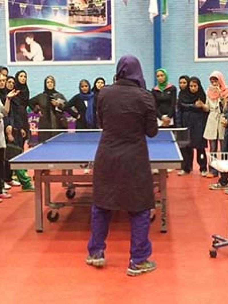 Group of women grouped around a table tennis table