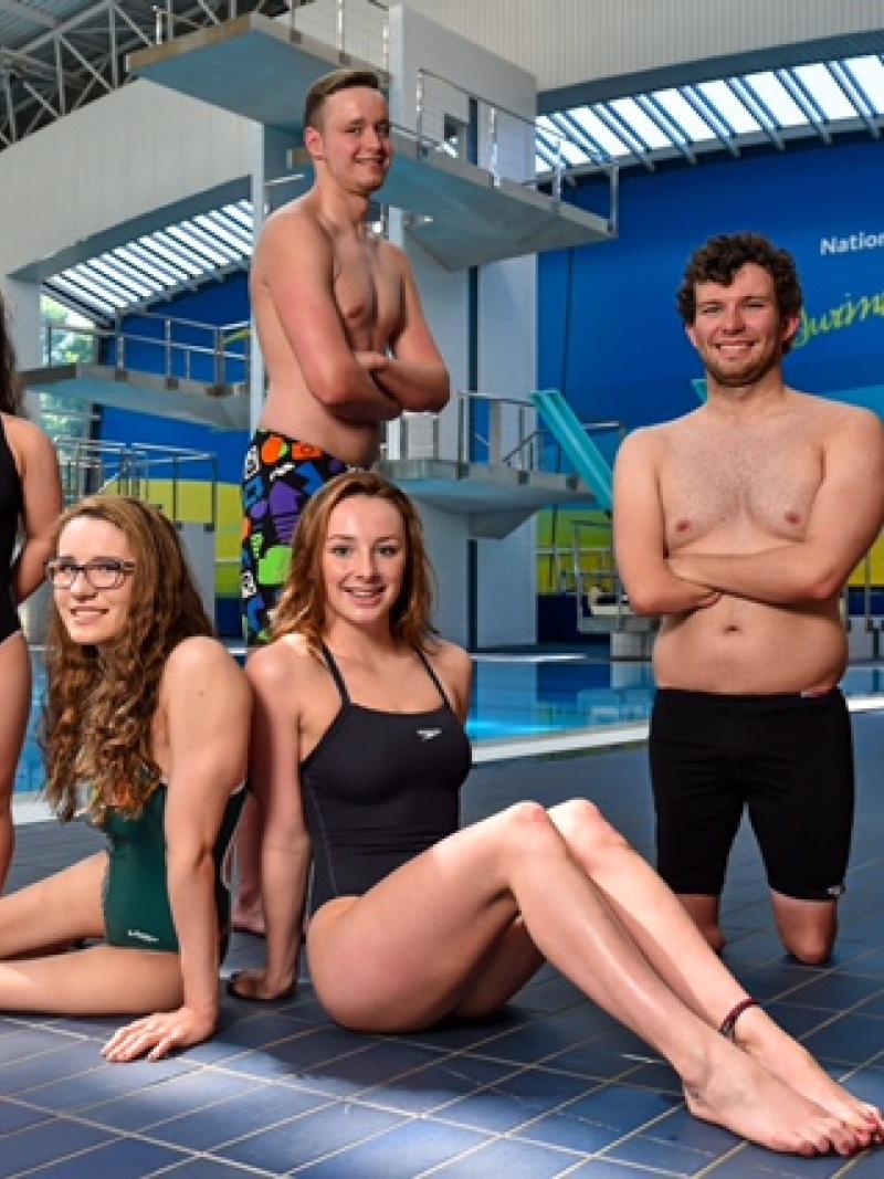 Group shot of swimmers in front of a pool