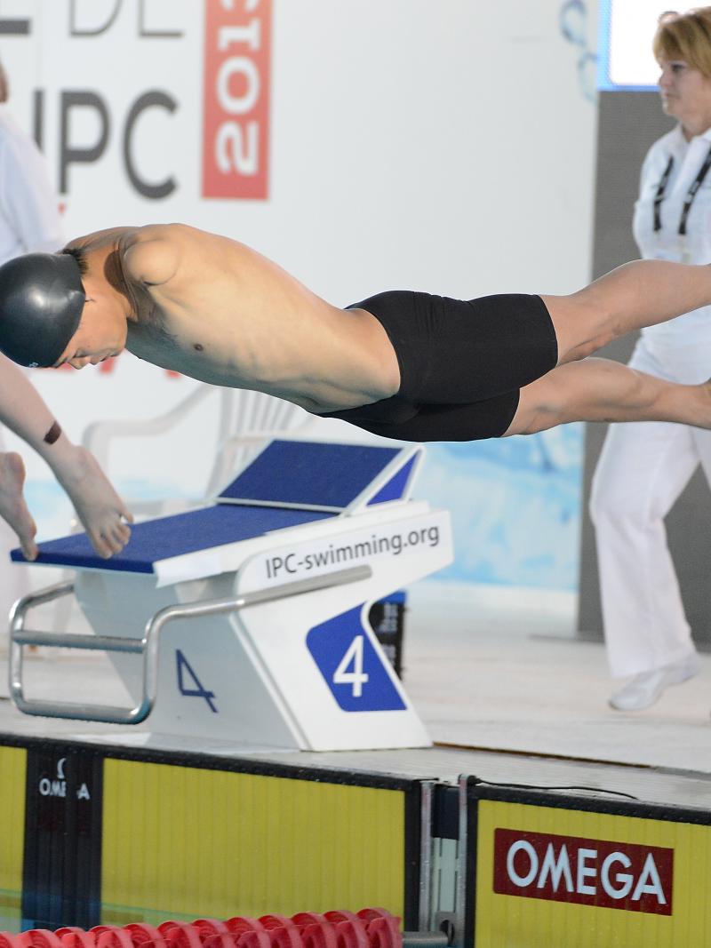 A swimmer without arms begins his race.