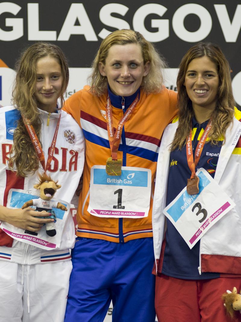 Three swimmers pose with their medals
