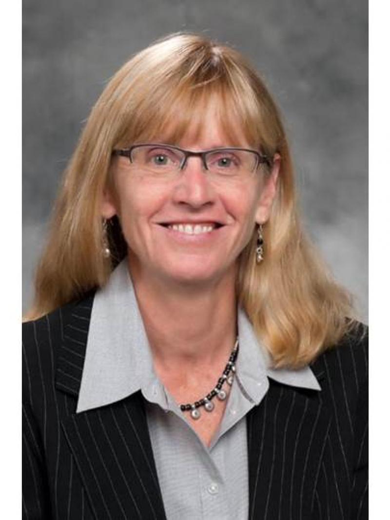 Portrait picture of a blonde woman wearing glasses
