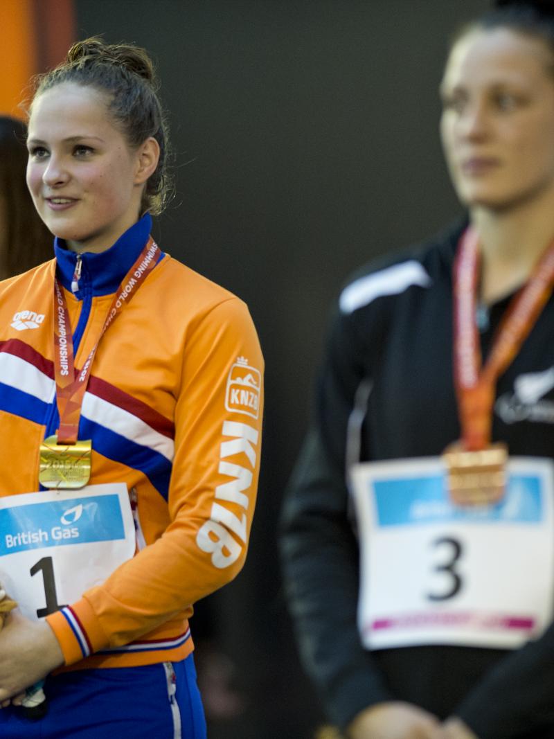 Three women in training suits on a podium