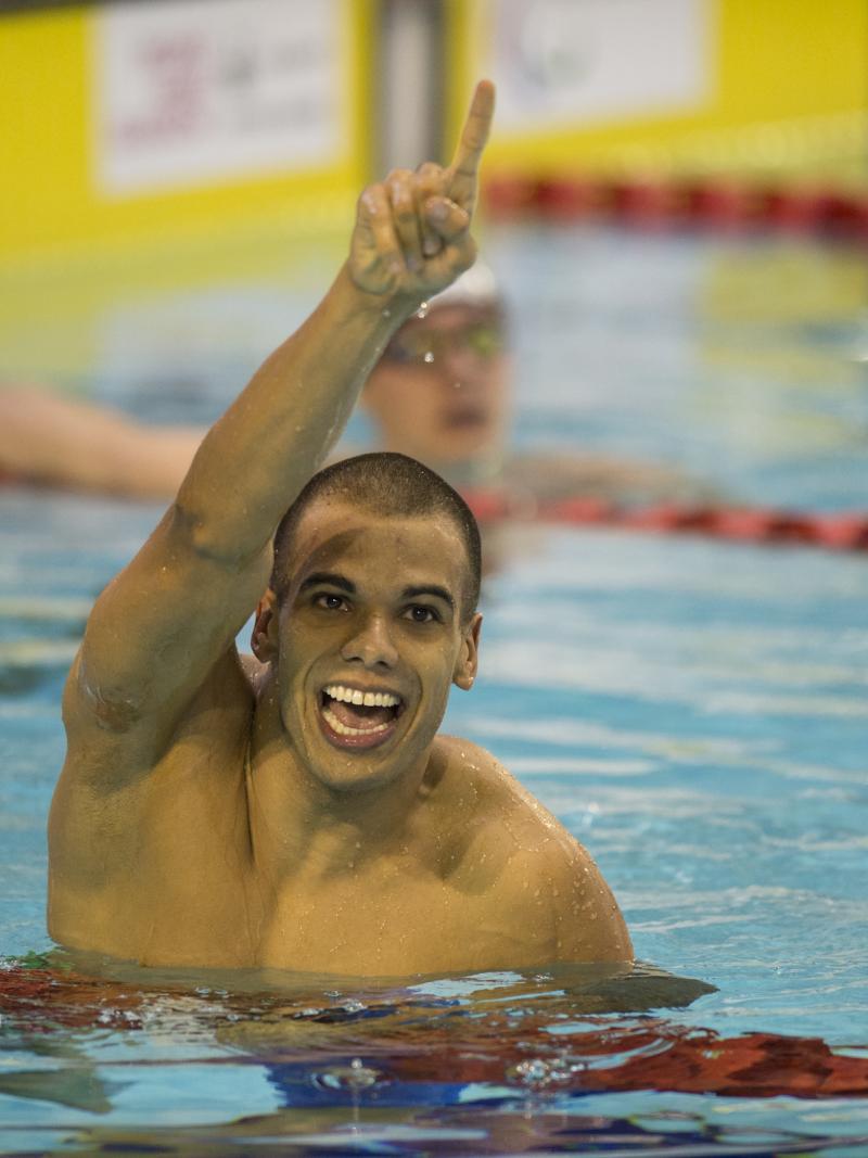 Man in water, holding one arm in the air, celebrating