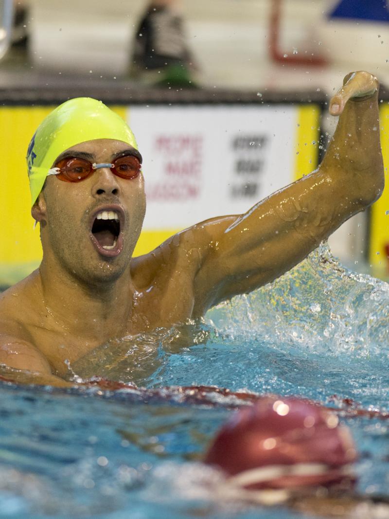 Man in the water, waving one arm in the air, celebrating