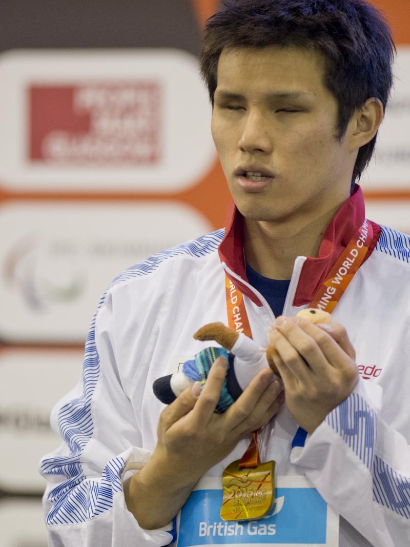 Man with a medal around his neck on a podium