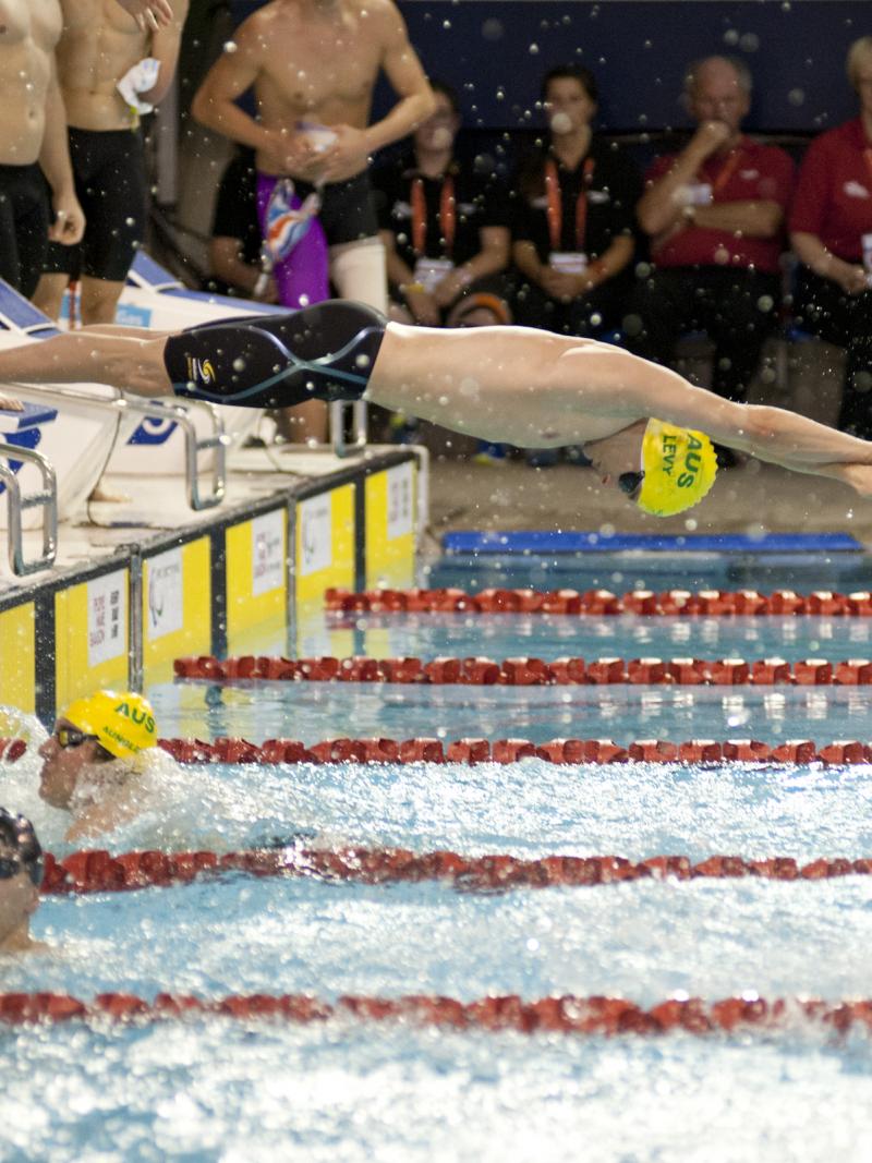 View on the starting zone in a swimming pool, one athlete jumping in the water