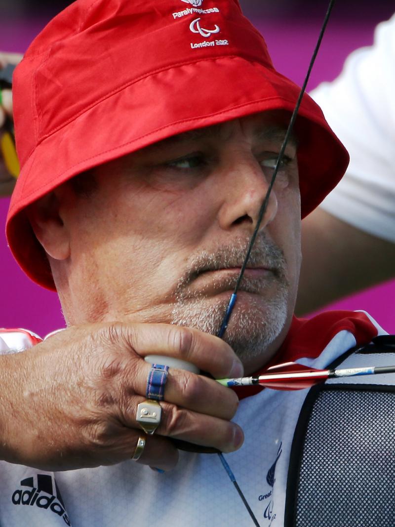 Close up of a man with a hat in an archery competition