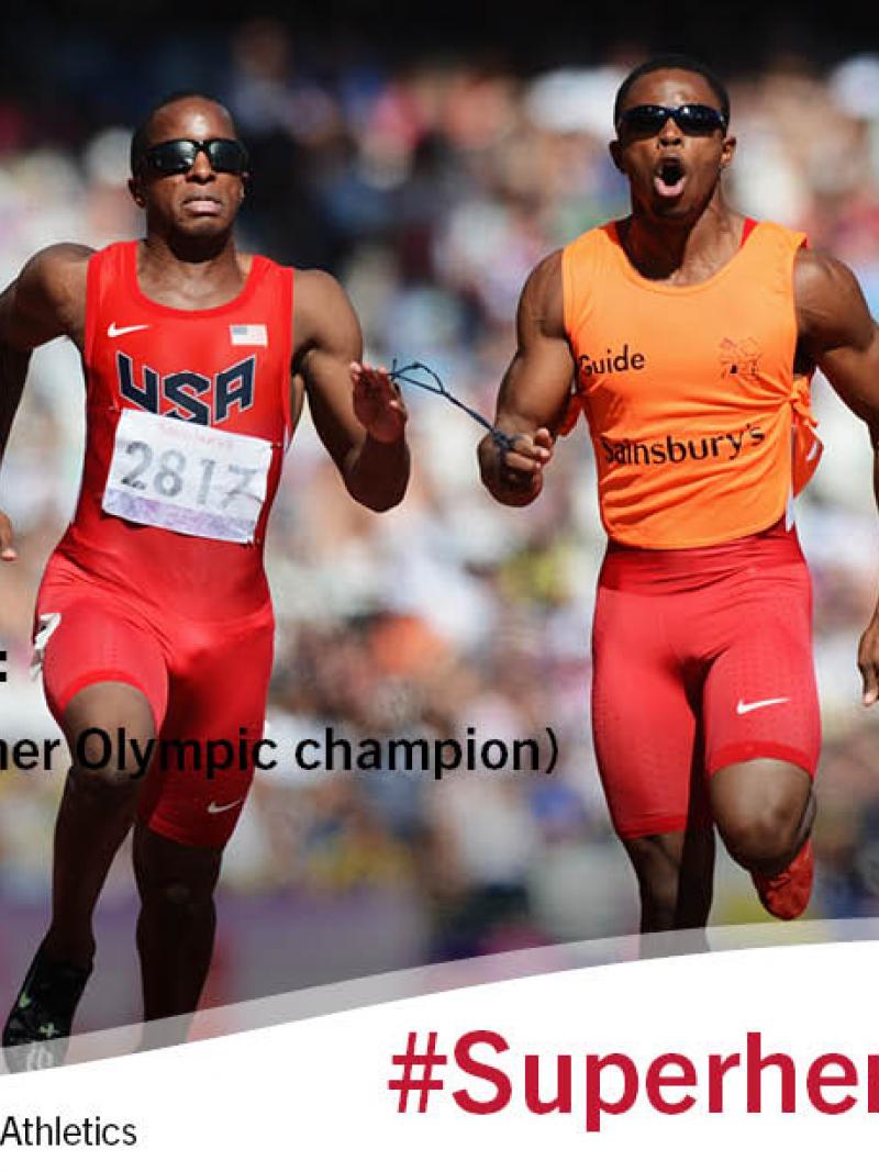 Man and his guide sprinting in a stadium