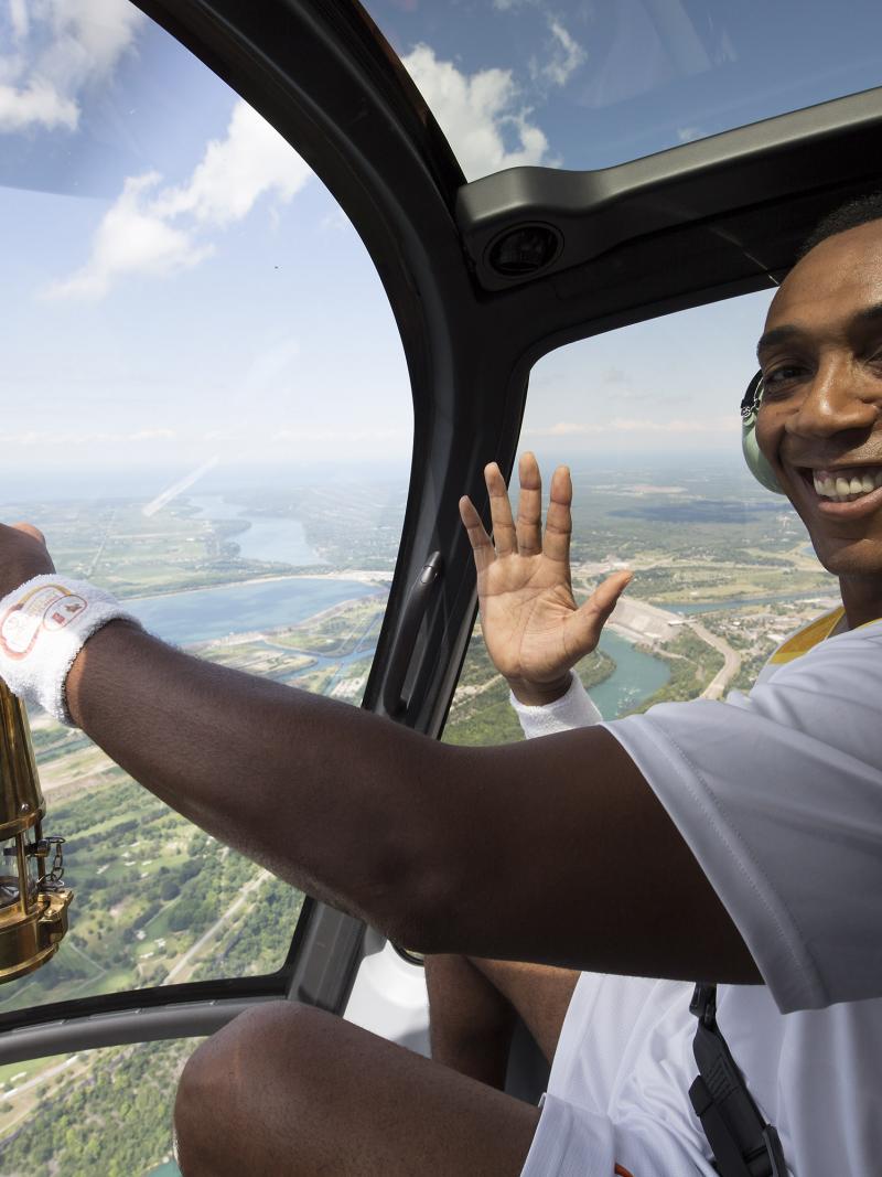 Dwight Drummond, CBC News Toronto co-host, carries the Parapan Am flame on board a helicopter in Niagara Falls, Ontario.