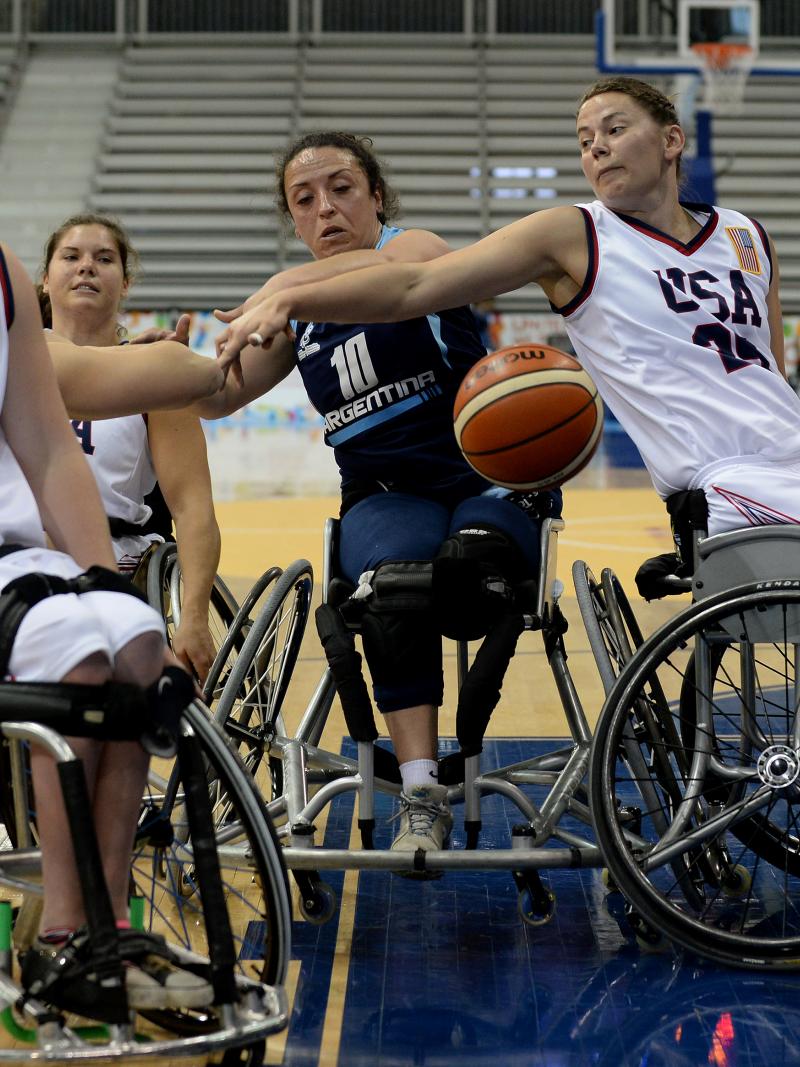 Two women in wheelchairs defending at a basketball game