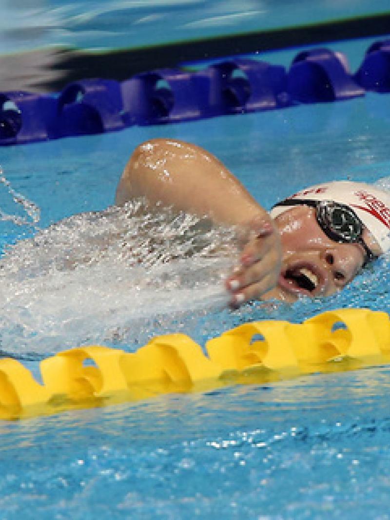 Tess Routliffe swimming in the pool. Her head is just above water and facing the camera.