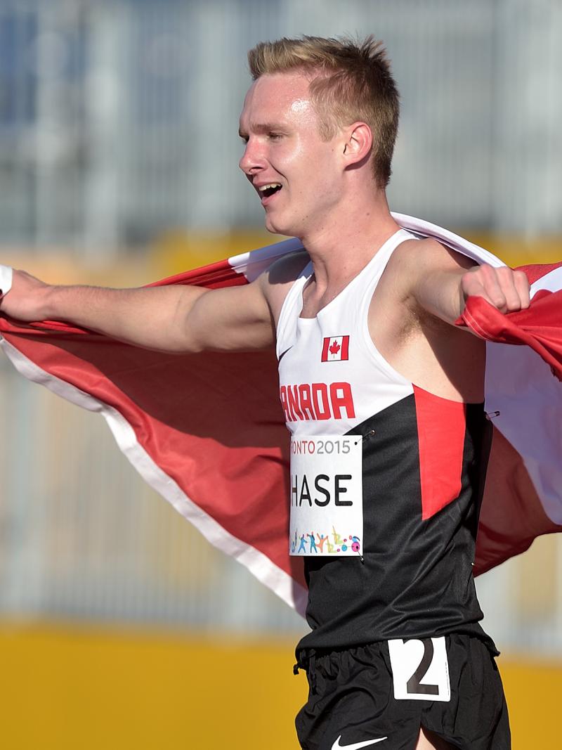 Mitchell Chase walks wrapped in the Canadian flag