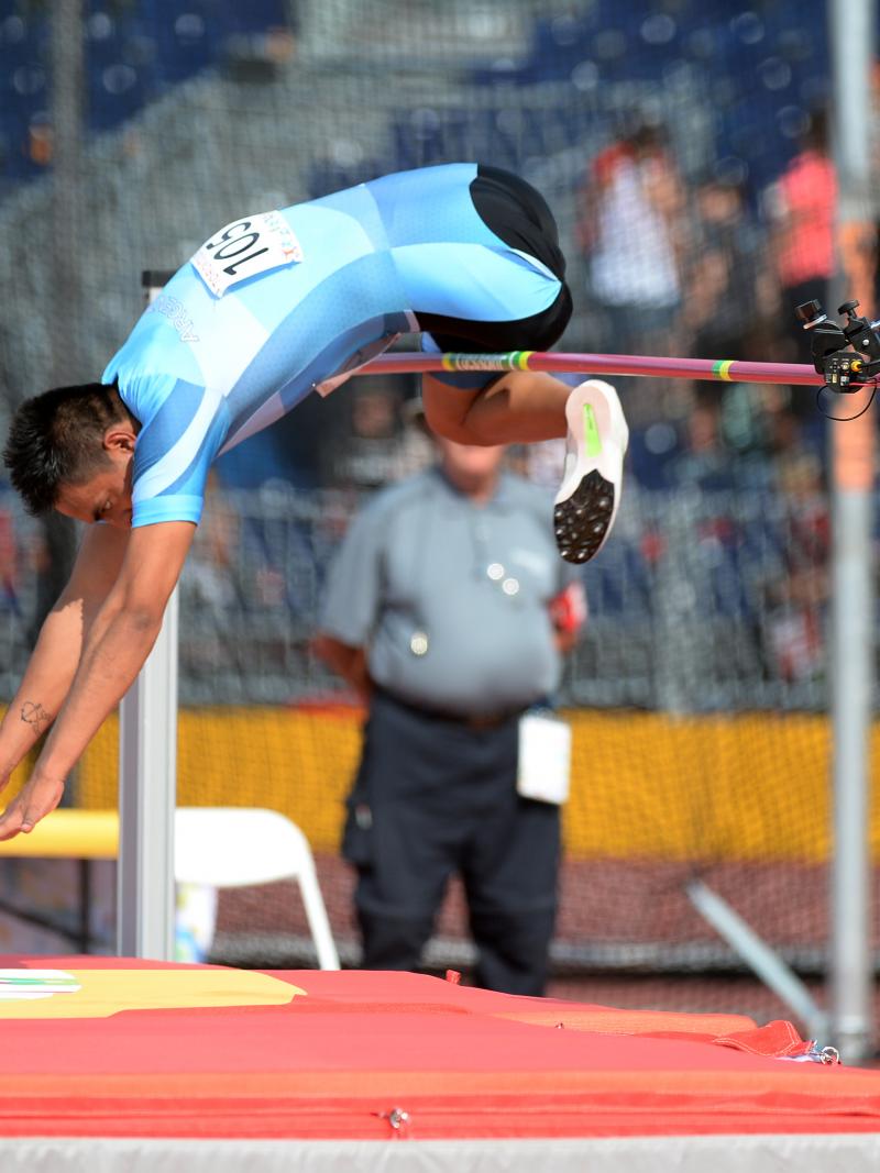 Man during a high jump in a stadium