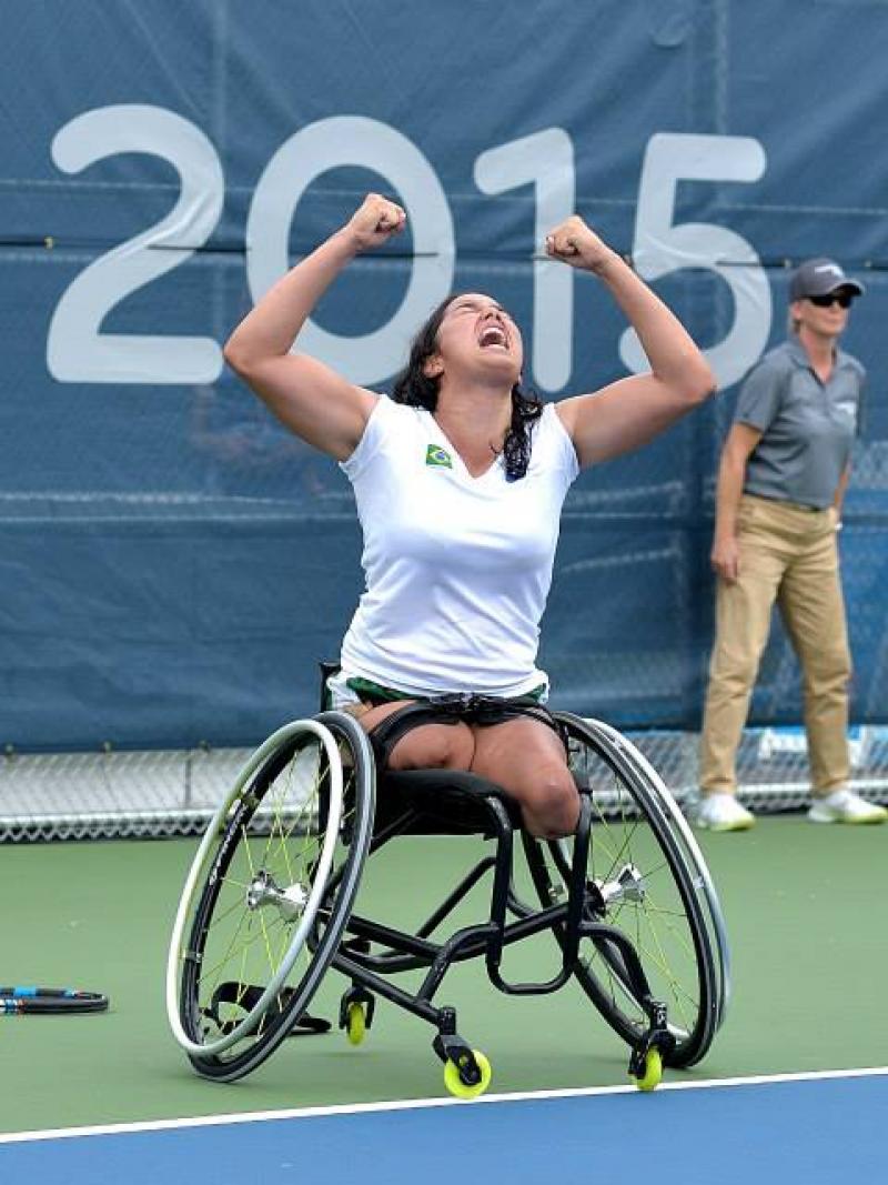 Natalia Mayara celebrating her victory with her hands in the air. She is looking at the sky, her mouth is open