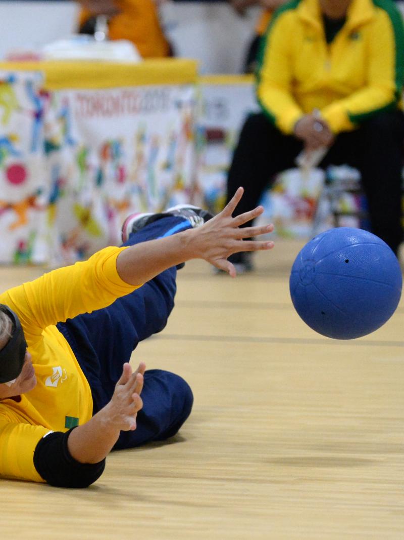 Blindfolded woman catching the ball during a goalball match
