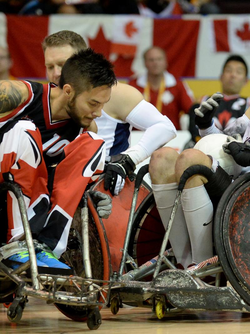 Two wheelchair rugby players tackeling each other