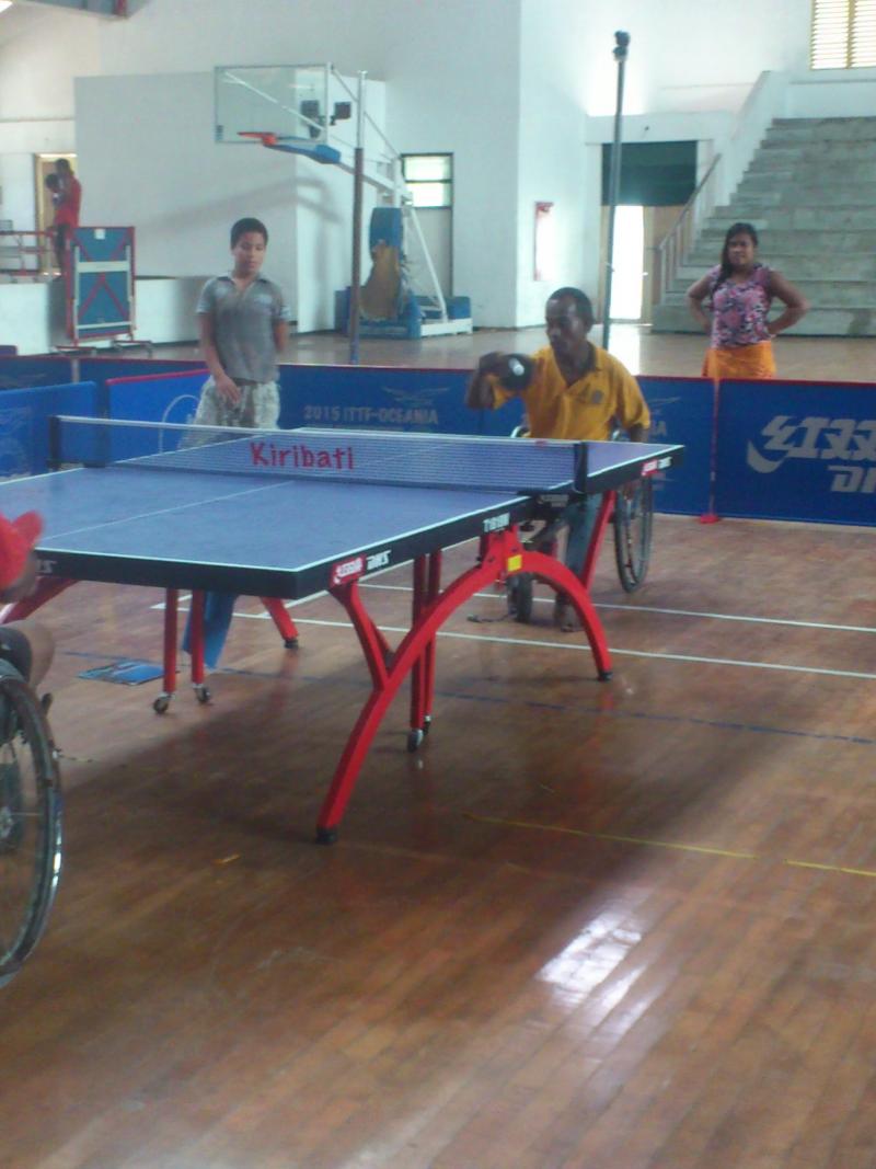 Two men in wheelchairs playing table tennis