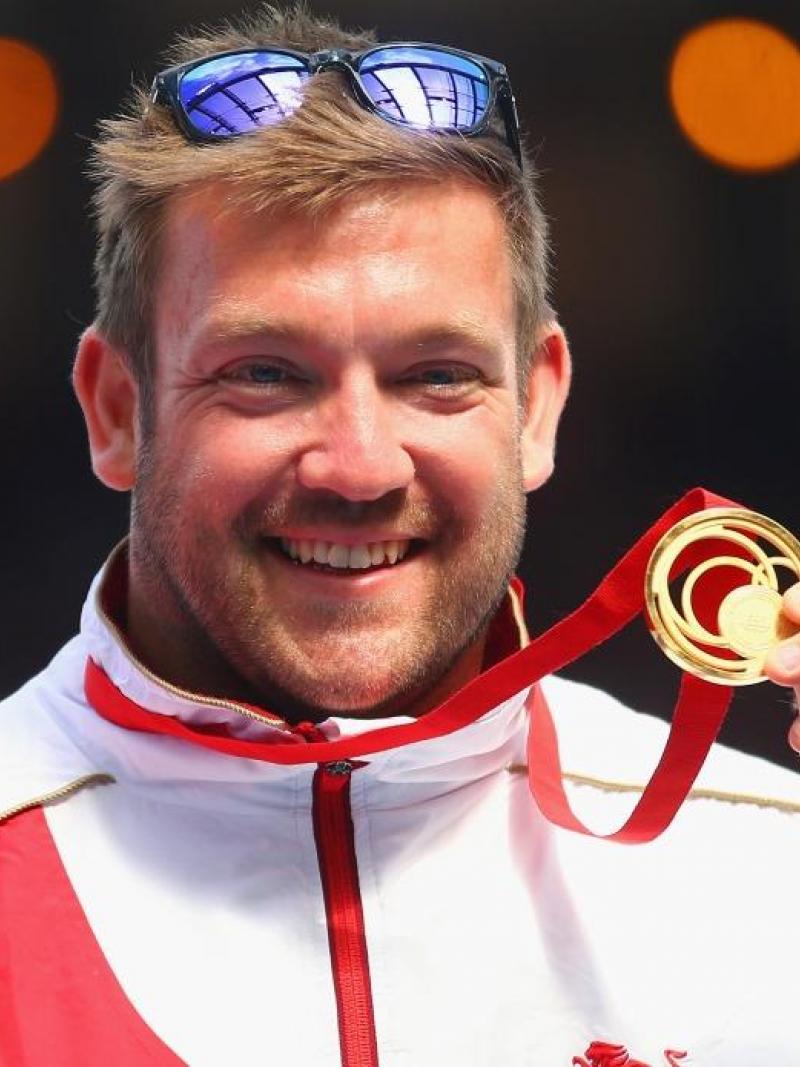 Gold medallist Dan Greaves of England poses on the podium during the medal ceremony for the Men's F42/44 Discus at Hampden Park during day five of the Glasgow 2014 Commonwealth Games 