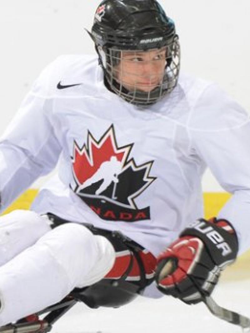 Man in a sledge, playing hockey on the ice