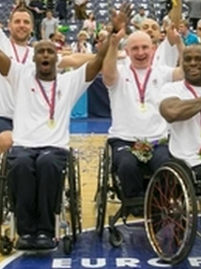Team photo of men sitting in wheelchairs on a basketball court