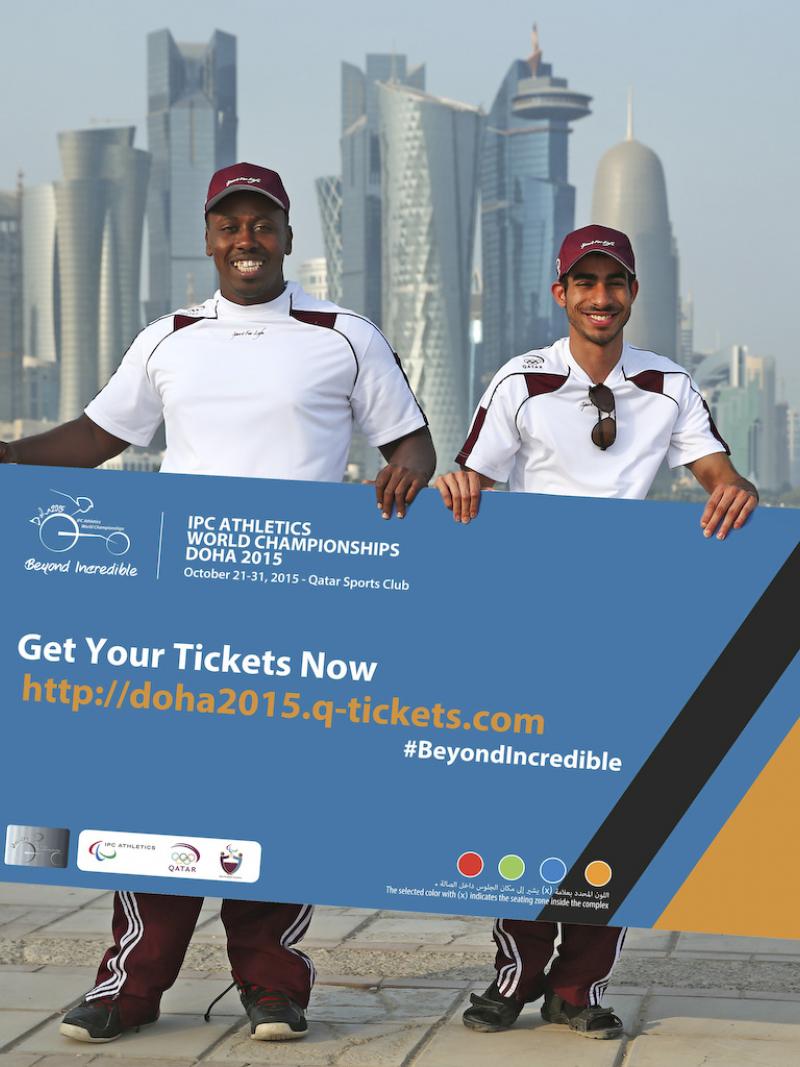 Two men holding a banner in front of a modern skyline
