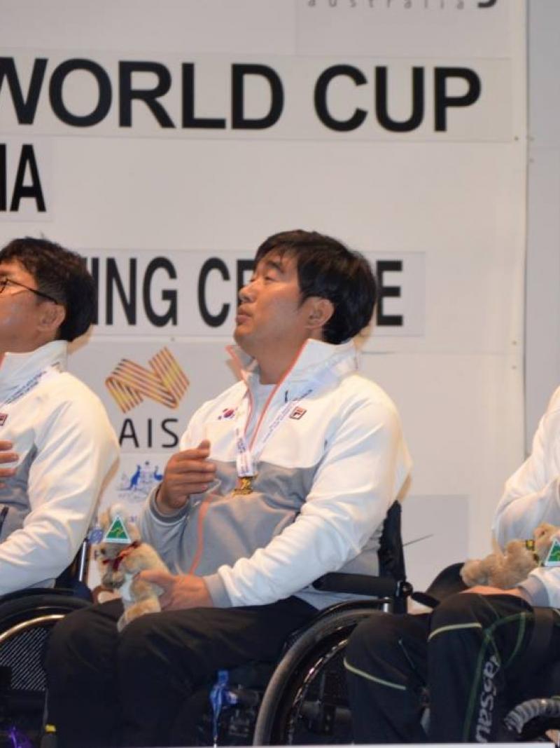 Three men in wheelchairs, having their hand on their chest