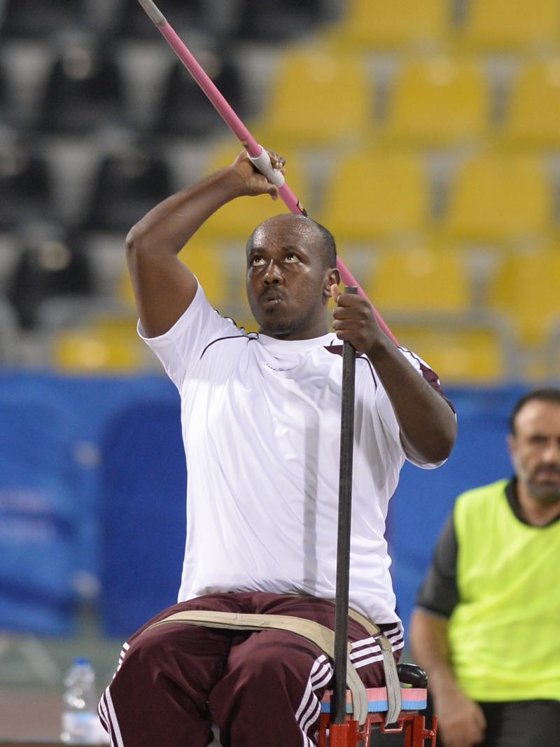 Man sitting, throwing a javelin